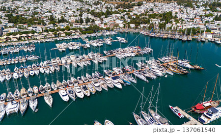 Aerial view of Bodrum marina filled with luxury yachts and sailboats surrounded by white houses and green hills. Popular Mediterranean travel destination in Turkey. 137061540