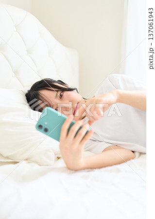 不安な表情でスマートフォンを見る女性 不安な表情でスマートフォンを見る女性 137061943