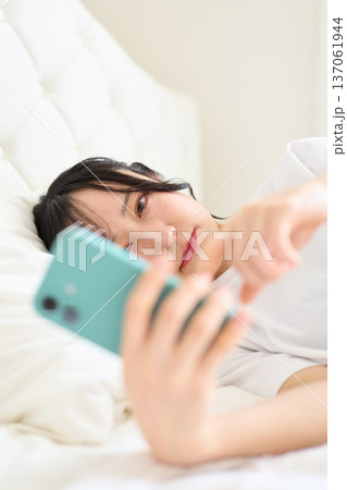 不安な表情でスマートフォンを見る女性 不安な表情でスマートフォンを見る女性 137061944