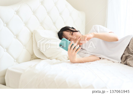不安な表情でスマートフォンを見る女性 137061945