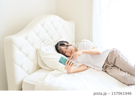 不安な表情でスマートフォンを見る女性 137061946