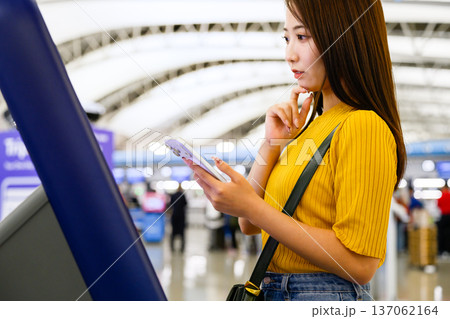 空港でスマホ操作する女性 ■撮影協力：関西国際空港（KIX） 137062164