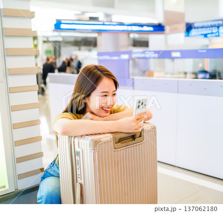 空港でスマホ操作する女性 ■撮影協力：関西国際空港（KIX） 137062180