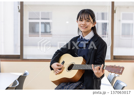 ギターを演奏する女子学生 137063017