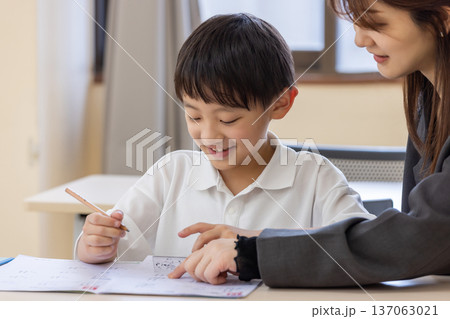学習する小学生と塾講師 137063021