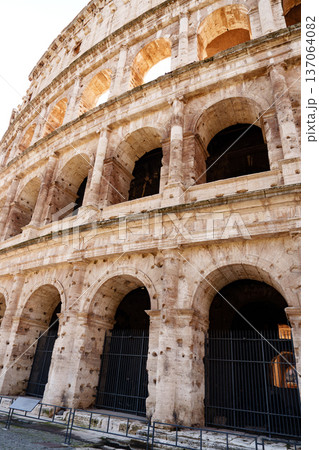 Views of the Colosseum in Rome showing its stone structure and arches during daylight 137064082