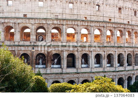 Visitors explore the Colosseum in Rome during the daytime with sculptures in view Visitors explore the Colosseum in Rome during the daytime with sculptures in view 137064083