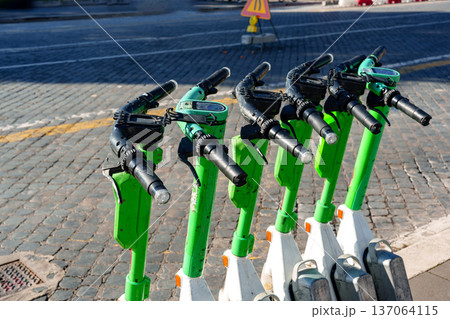 Scooters parked on city street during the day near pavement and traffic signs Scooters parked on city street during the day near pavement and traffic signs 137064115