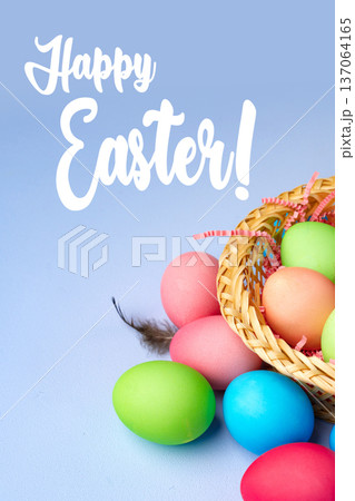 Festive basket filled with colorful Easter eggs on a light blue background Festive basket filled with colorful Easter eggs on a light blue background 137064165