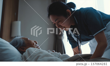 高齢者をベッドで介助する女性介護士 137064281