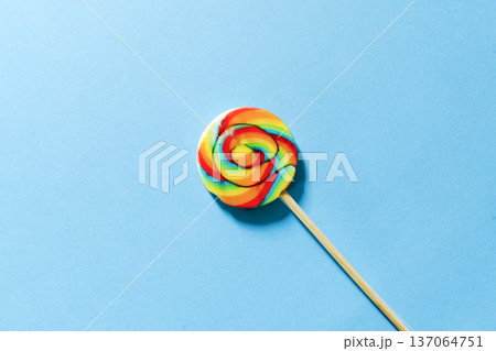 Swirl lollipop on a blue background colorful candy concept 137064751