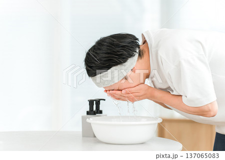 ヘアバンドをして洗顔をする若いアジア人男性 ヘアバンドをして洗顔をする若いアジア人男性 137065083