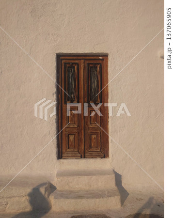 Traditional Wooden Door on White Wall in Mykonos Greece Traditional Wooden Door on White Wall in Mykonos Greece 137065905