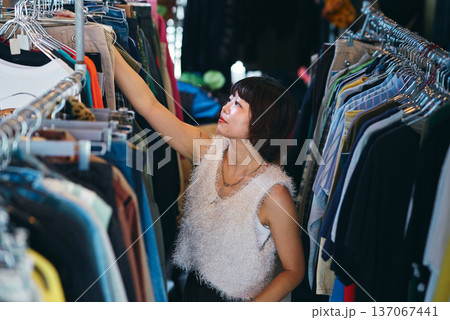古着屋で洋服を探す若い女性 古着屋で洋服を探す若い女性 137067441