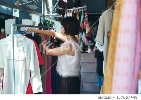 古着屋で洋服を探す若い女性 古着屋で洋服を探す若い女性 137067449