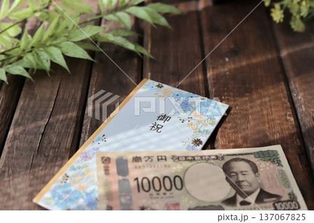 水色で花柄のご祝儀袋と新札の一万円　入学祝や進学祝などの御祝儀 137067825