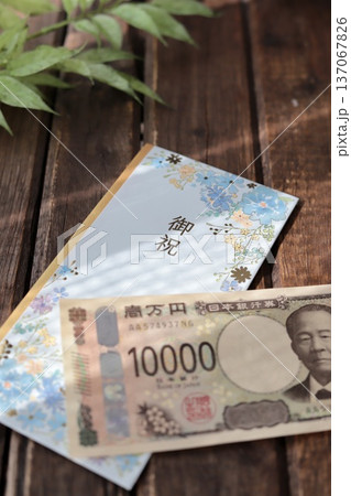 水色で花柄のご祝儀袋と新札の一万円　入学祝や進学祝などの御祝儀 137067826