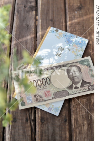 水色で花柄のご祝儀袋と新札の一万円　入学祝や進学祝などの御祝儀 137067827