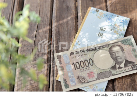 水色で花柄のご祝儀袋と新札の一万円 入学祝や進学祝などの御祝儀 水色で花柄のご祝儀袋と新札の一万円 入学祝や進学祝などの御祝儀 137067828