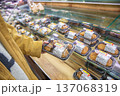 スーパーで割引きシールが張っている弁当・総菜を手に取る女性 137068319