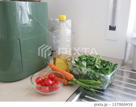 Fresh vegetables and sunflower oil in kitchen next to air fryer. High-quality homemade ingredients from farmers. Healthy eating. Traditional Italian cuisine. Fresh vegetables and sunflower oil in kitchen next to air fryer. High-quality homemade ingredients from farmers. Healthy eating. Traditional Italian cuisine. 137068458