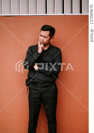 Thoughtful Man in Black Shirt Pondering a Solution Deeply Thoughtful Man in Black Shirt Pondering a Solution Deeply 137069670