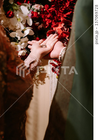 Couple's hands holding elegant wedding rings during ceremony 137069728