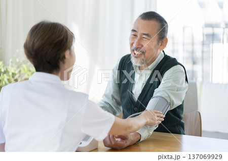医療スタッフに血圧測定をしてもらう70代の男性 医療スタッフに血圧測定をしてもらう70代の男性 137069929