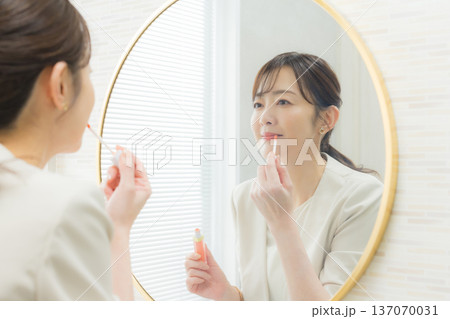 鏡を見てメイクする女性 鏡を見てメイクする女性 137070031