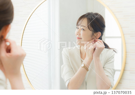 鏡を見てメイクする女性 鏡を見てメイクする女性 137070035