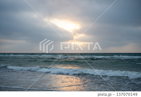 Moody Baltic sea waves at sunset with dramatic cloudy sky and golden light Moody Baltic sea waves at sunset with dramatic cloudy sky and golden light 137070149