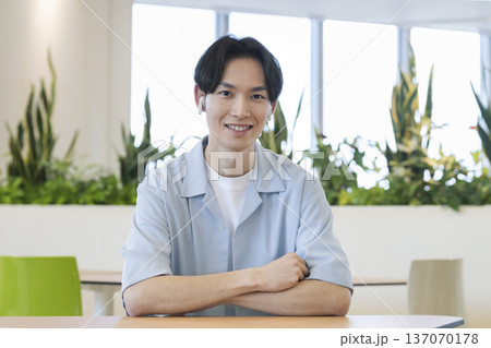 カメラ目線で笑顔のイヤホンをつけた30代男性 137070178