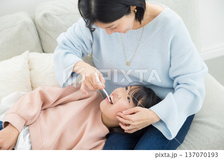 小学生に仕上げ磨きをするママ 小学生に仕上げ磨きをするママ 137070193