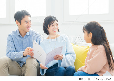 リビングで通知表を見る家族　 137070492