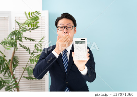 計算機を持ち驚く男性 137071360