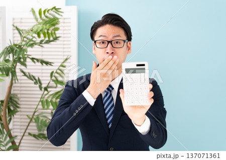 計算機を持ち驚く男性 137071361