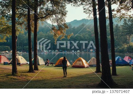 Serene Solo Camper Gazing at Clear Summer Blue Sky by Tranquil Lake Surrounded by Trees 137071407