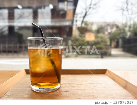 窓辺で楽しむアイスティー（氷入りグラス・カフェ風景） 137073017