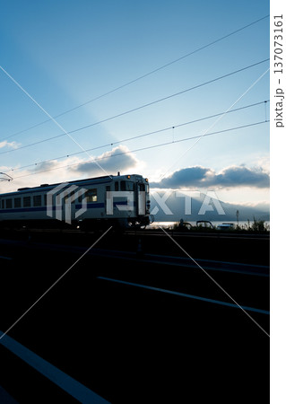 朝日を浴びながら走る電車 137073161