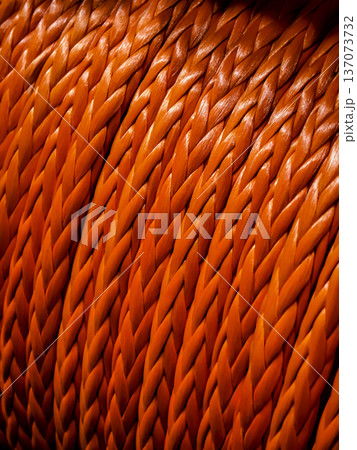 Close up view of woven orange rope showing detailed patterns and texture in a workshop setting Close up view of woven orange rope showing detailed patterns and texture in a workshop setting 137073732