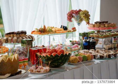 Elegant Wedding Dessert Buffet with Fresh Fruits, Pastries, and Colorful Treats Displayed on Tiered Tables Elegant Wedding Dessert Buffet with Fresh Fruits, Pastries, and Colorful Treats Displayed on Tiered Tables 137073864