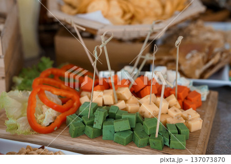 Colorful Cheese and Veggie Platter with Red Peppers, Green Herbed Cubes, and Crudites on Wooden Board Colorful Cheese and Veggie Platter with Red Peppers, Green Herbed Cubes, and Crudites on Wooden Board 137073870