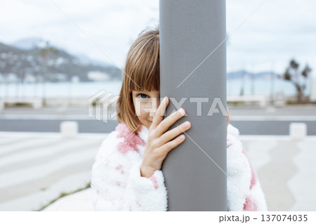 little cute blond girl curious smiling playing outside on sea, lifestyle people concept little cute blond girl curious smiling playing outside on sea, lifestyle people concept 137074035