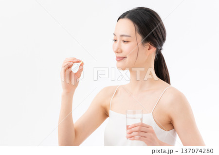 白背景でサプリを飲む女性の健康イメージ 白背景でサプリを飲む女性の健康イメージ 137074280