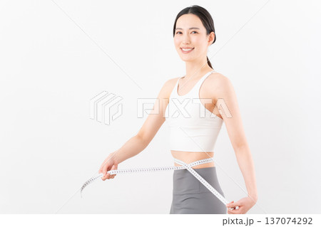 白背景でダイエットをする女性のビューティーイメージ 137074292