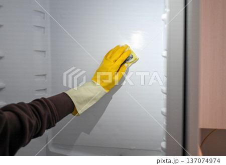 Manual freezer cleaning with protective glove and sponge during defrosting Manual freezer cleaning with protective glove and sponge during defrosting 137074974