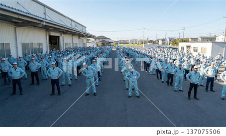 広大な工場の敷地で整列し準備運動をする作業員の集団 全身 俯瞰 137075506