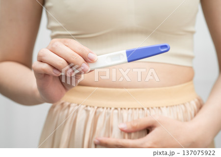 Asian holding pregnancy test for female of ovulation day, fetus, maternity, childbirth, birth control. 137075922