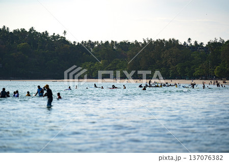 A Lot of People play and surf on Kata beach from Tele Lens Camera view, a beautiful shot represent the relaxed vacation in Phuket Province, Thailand. 137076382