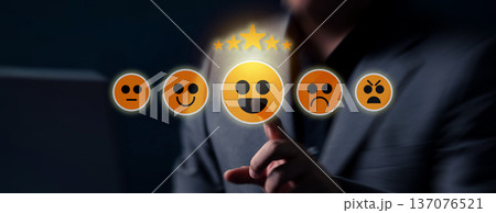 A hand selects a positive emoji on a touchscreen interface, triggering a five star customer rating within an interactive digital review system. 137076521